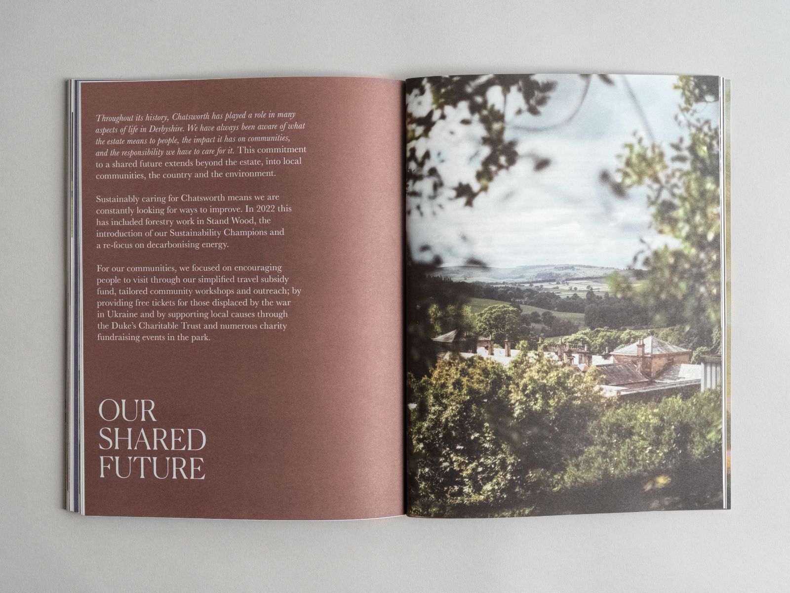 An open copy of the Chatsworth House Trust Annual Review. OUR SHARED FUTURE. A view over the Chatsworth Estate.