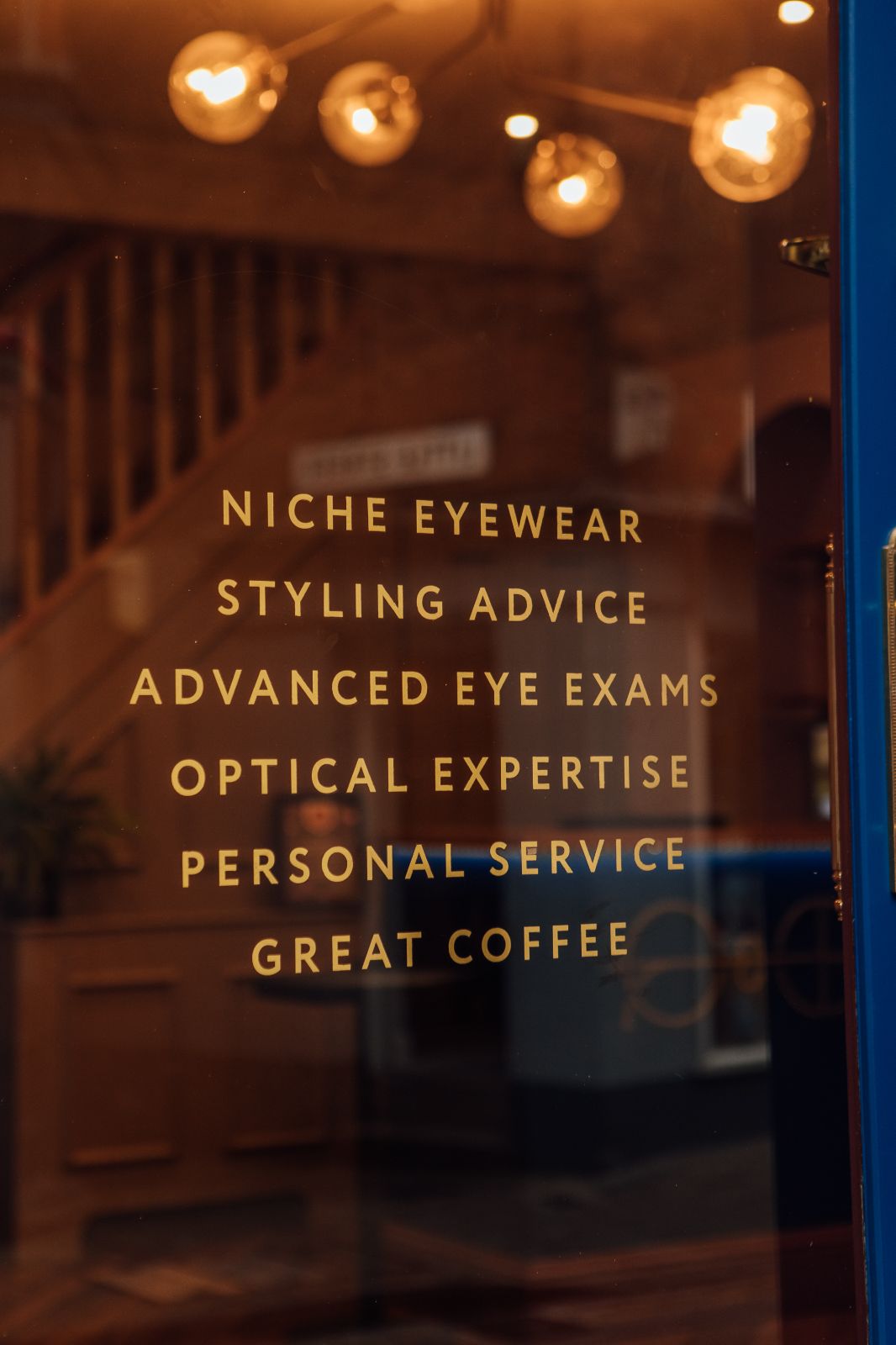 Painted on window: Niche eyewear, styling advice, advanced eye exams, optical expertise, personal service, great coffee