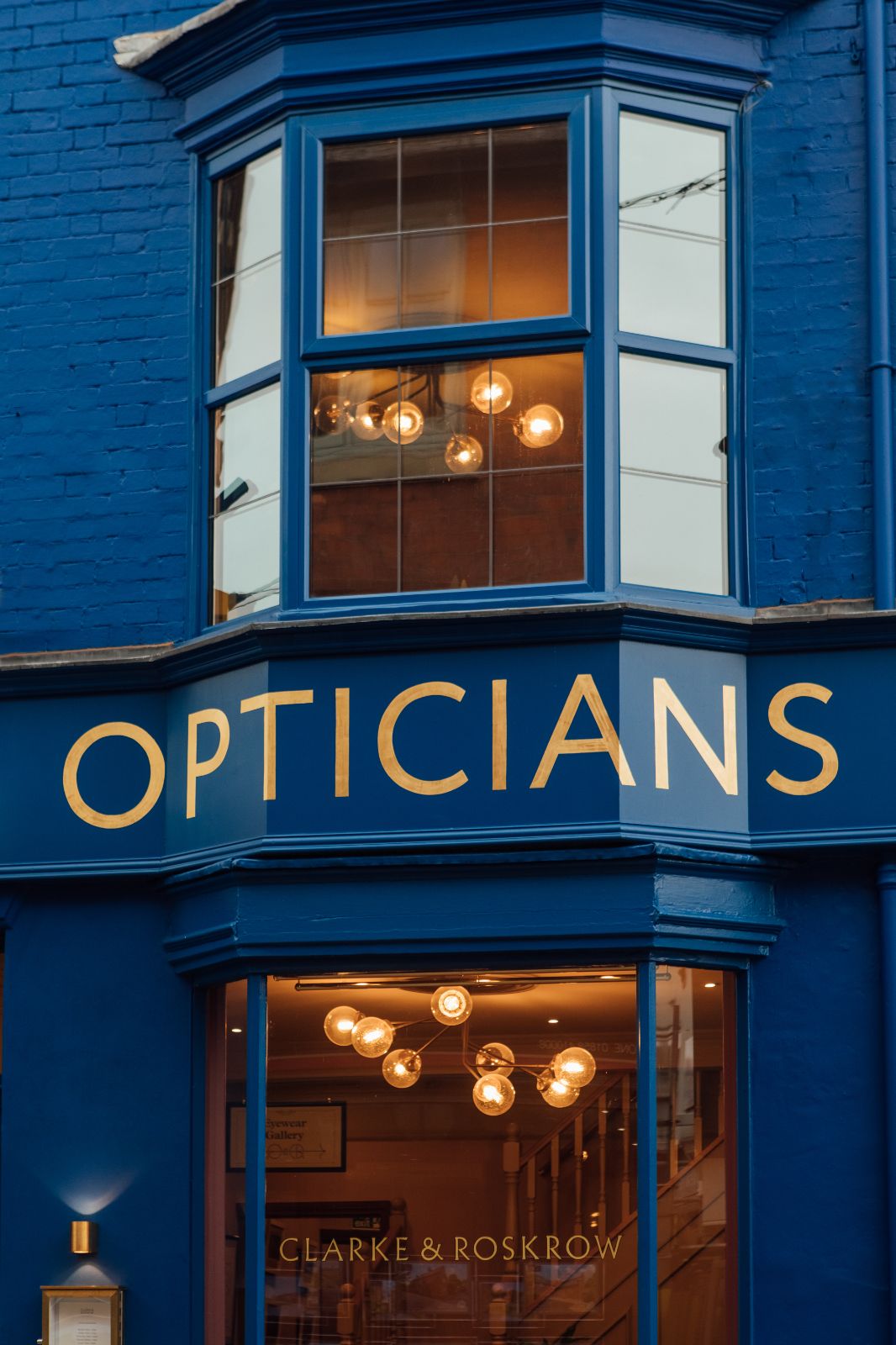 View of Clarke and Roskrow, blue building with OPTICIANS in gold signwriting