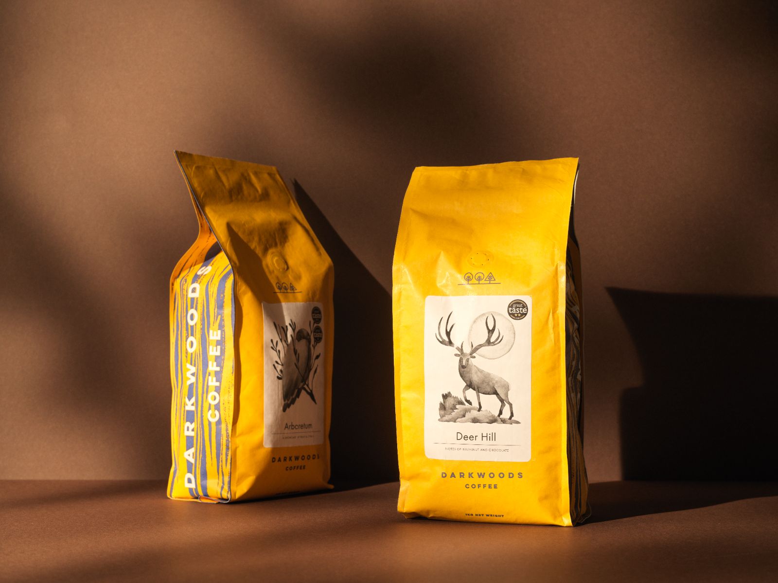 93 branding for Dark woods wholesale coffee. Two yellow bags with an owl and stag motif. Great Taste award sticker on bag. 