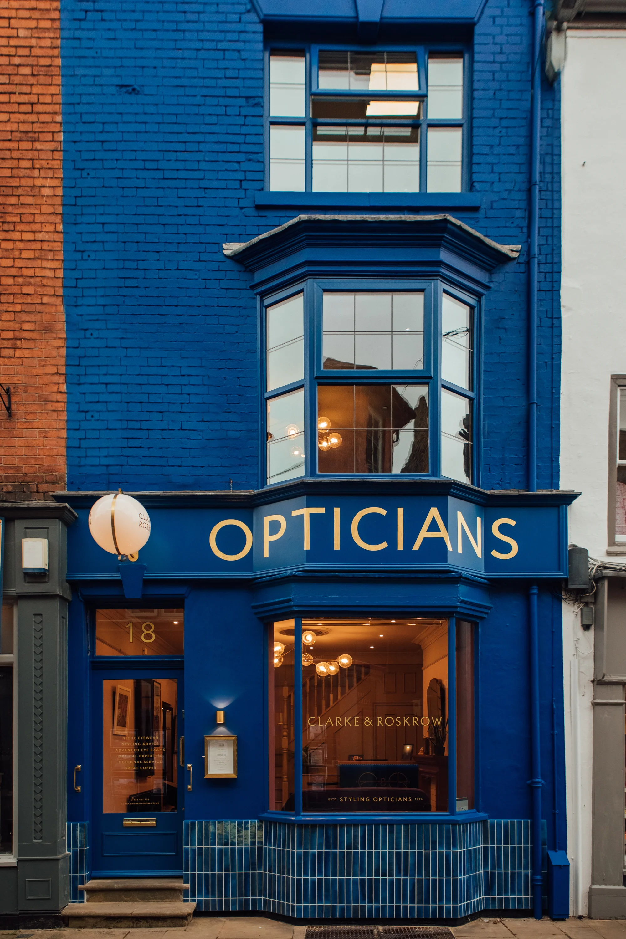 View of Clarke and Roskrow, blue building with OPTICIANS in gold signwriting