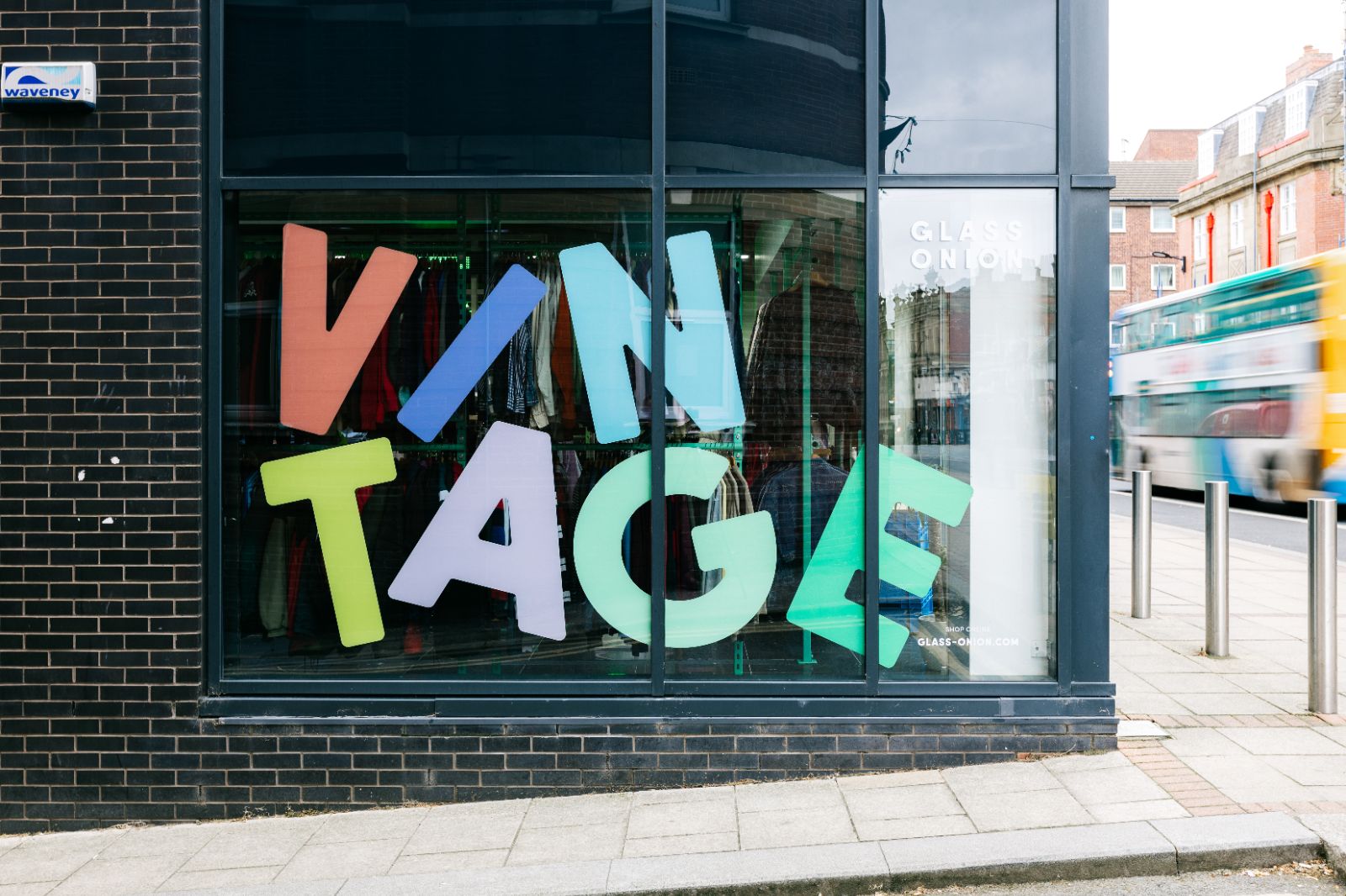 Large side window of Glass Onion’s Sheffield store with big multi-coloured vinyl letters reading Vintage in a stacked design. 