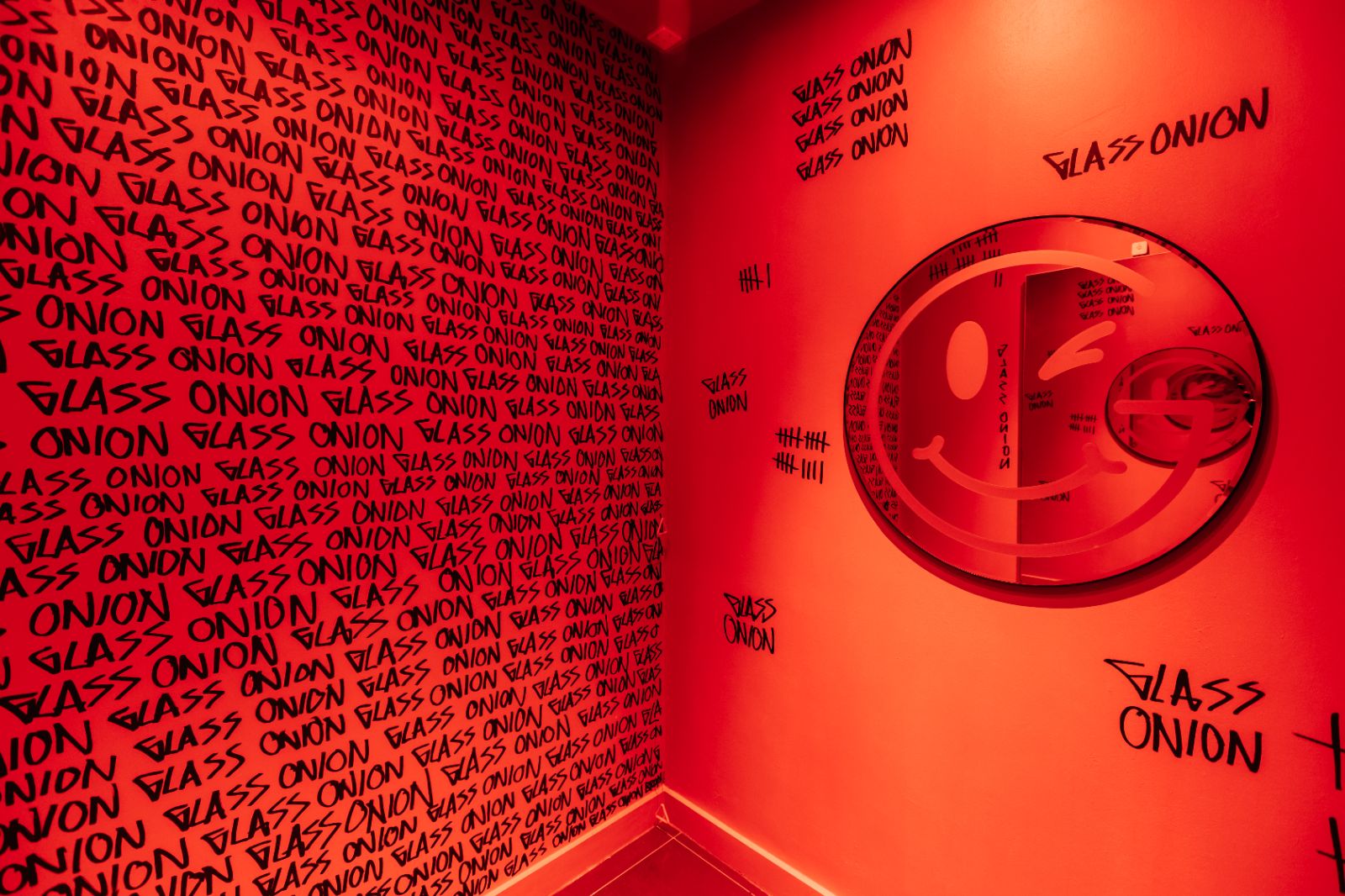 Red changing room with circular mirror with smiley face design 