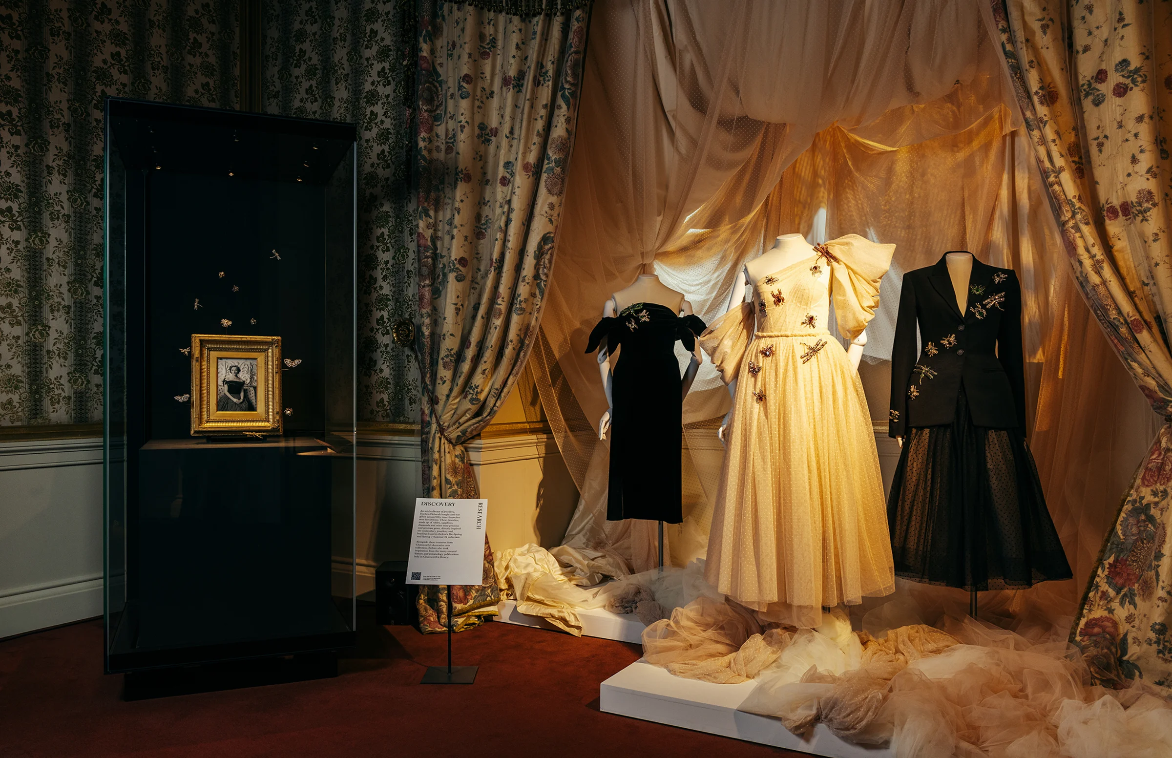 Wide shot image of dresses, golden framed Duchess image and signage