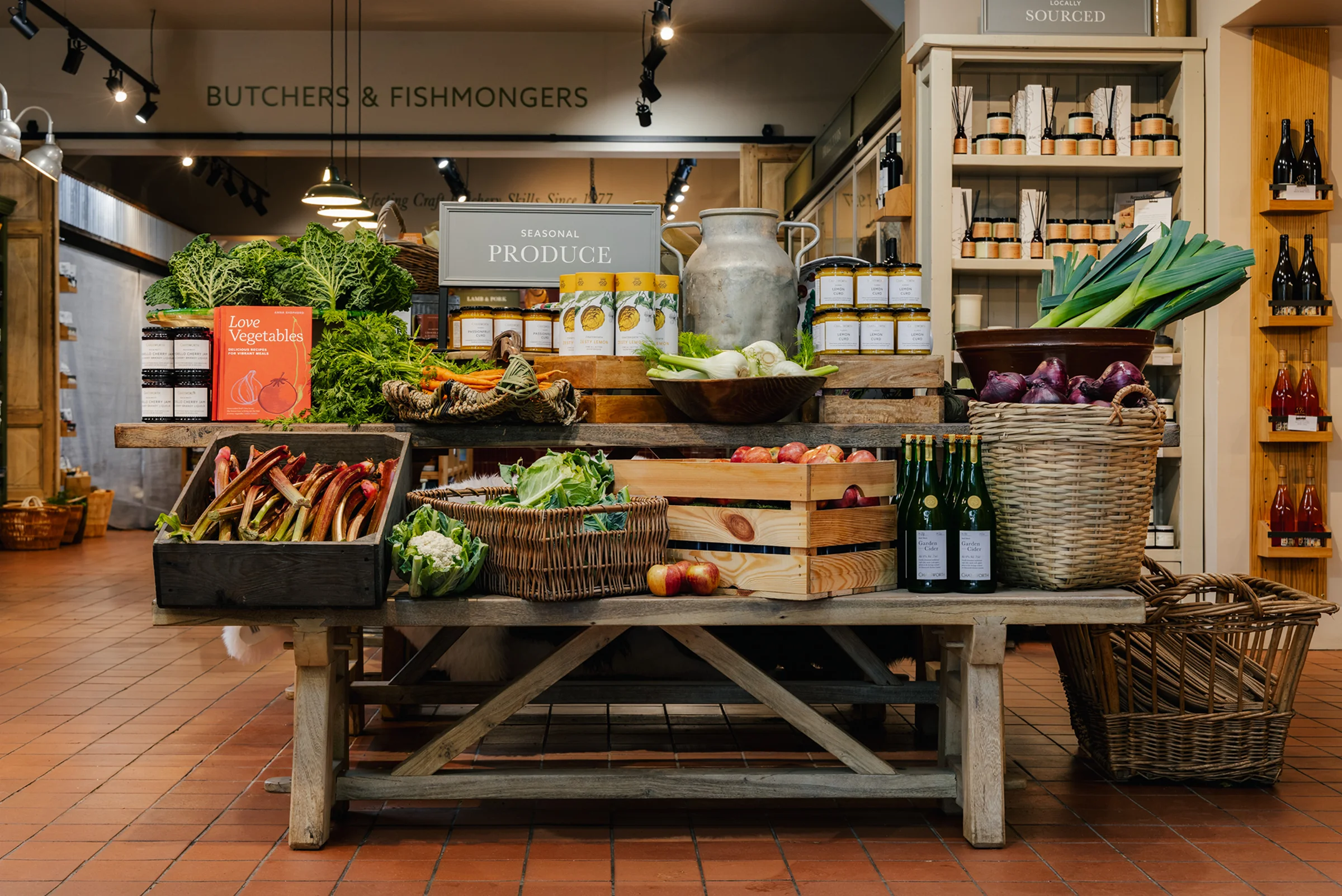 Reclaimed wooden table with stacked fresh produce and products