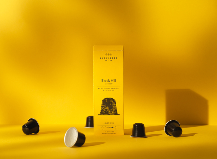 Dark woods coffee black pods on yellow background. 93 packaging design for Black Hill Espresso, 10 Nespresso compatible pods