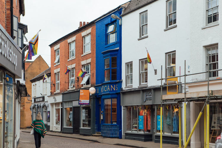 A wider street view of Clarke & Roskrow. The blue of the building stands out from the other neighbouring retail units.