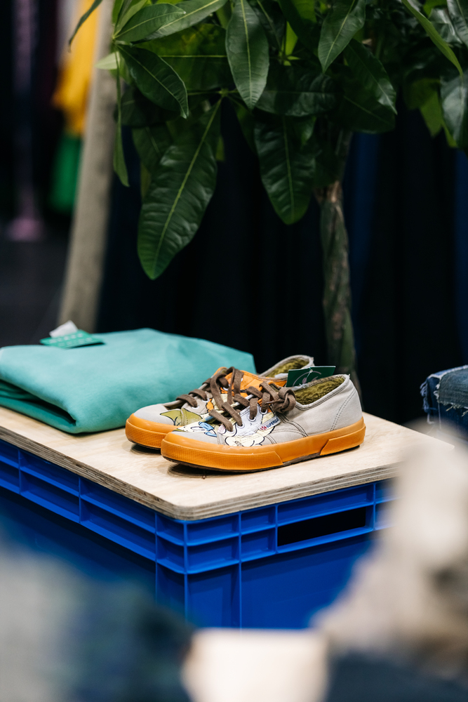 Upcycled crates & plywood board as display for vintage customised shoes & clothing with plant in background