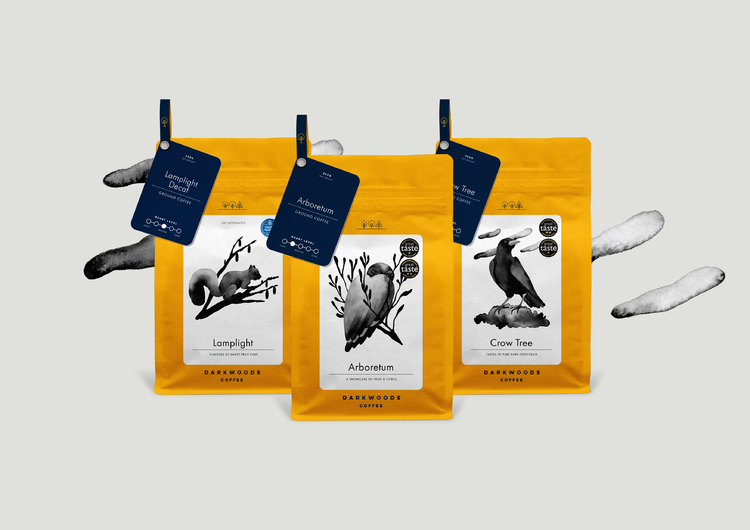 3 yellow coffee bags watercolour illustrations of different animals on each & a navy tasting note tag from corner